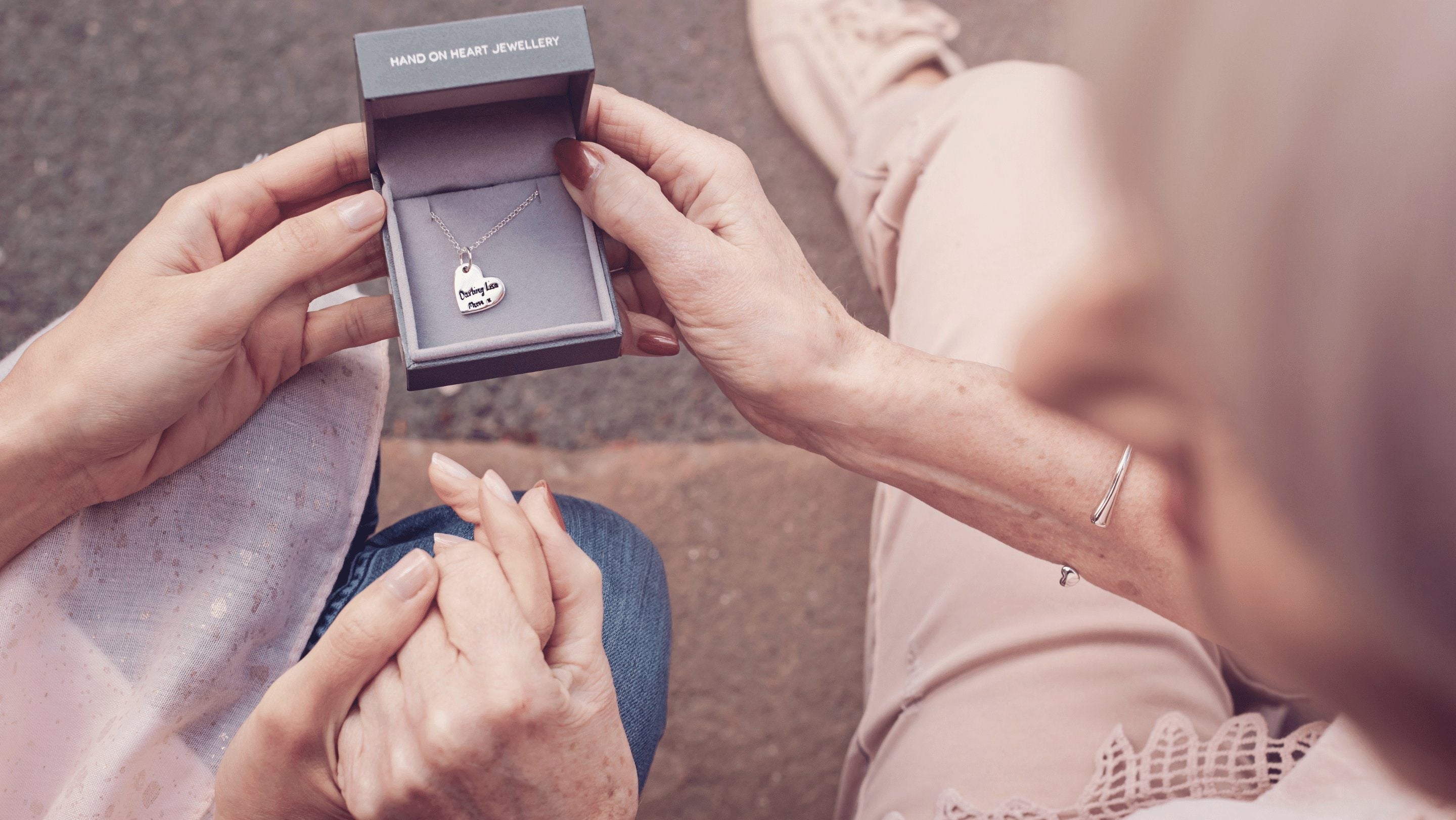 Two women holding a jewellery box containing a Handwriting Heart Necklace