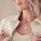 an image focussed on a blonde lady's neckline as she wears a silver oval necklace filled with cremation ashes