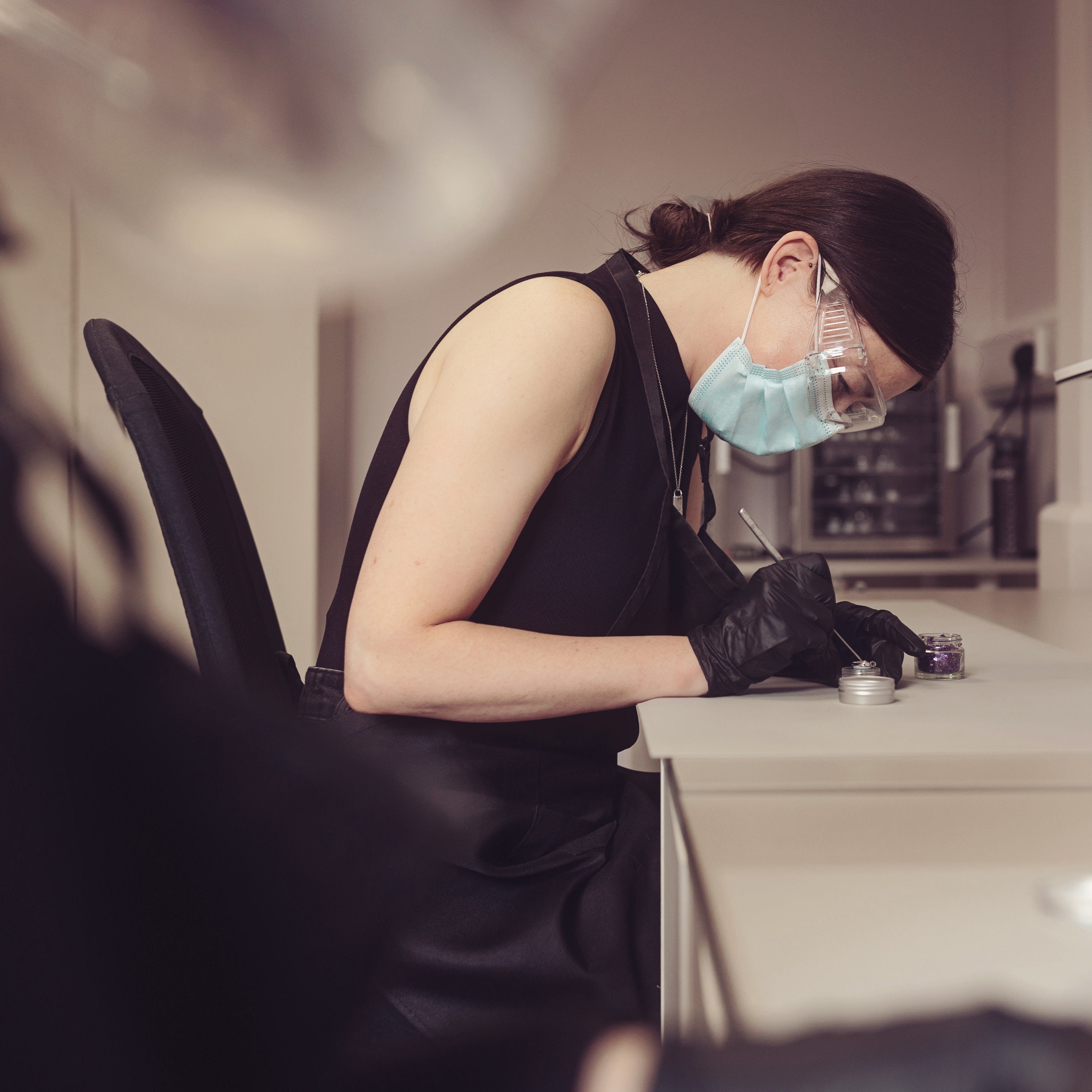 Woman wearing a protective glasses, mask and gloves crafting a piece of horse hair jewellery