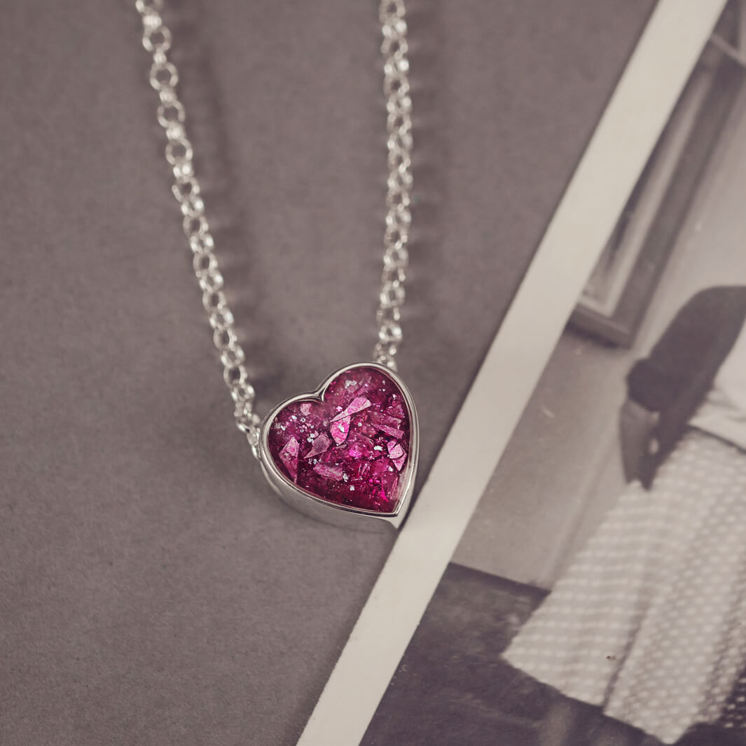 pink heart pendant, filled with crystals, glitter and memorial ashes, on a silver chain.