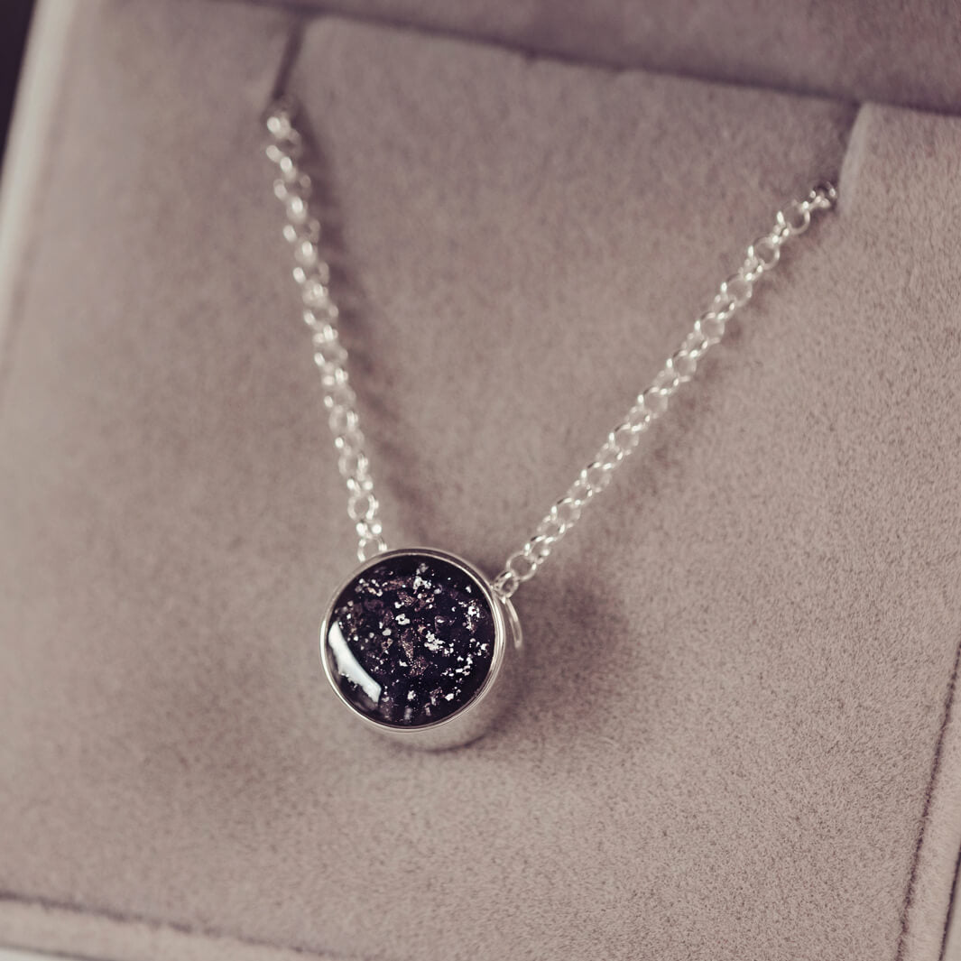 Round silver charm on silver chain, filled with black crystal, glitter, resin & ashes. 