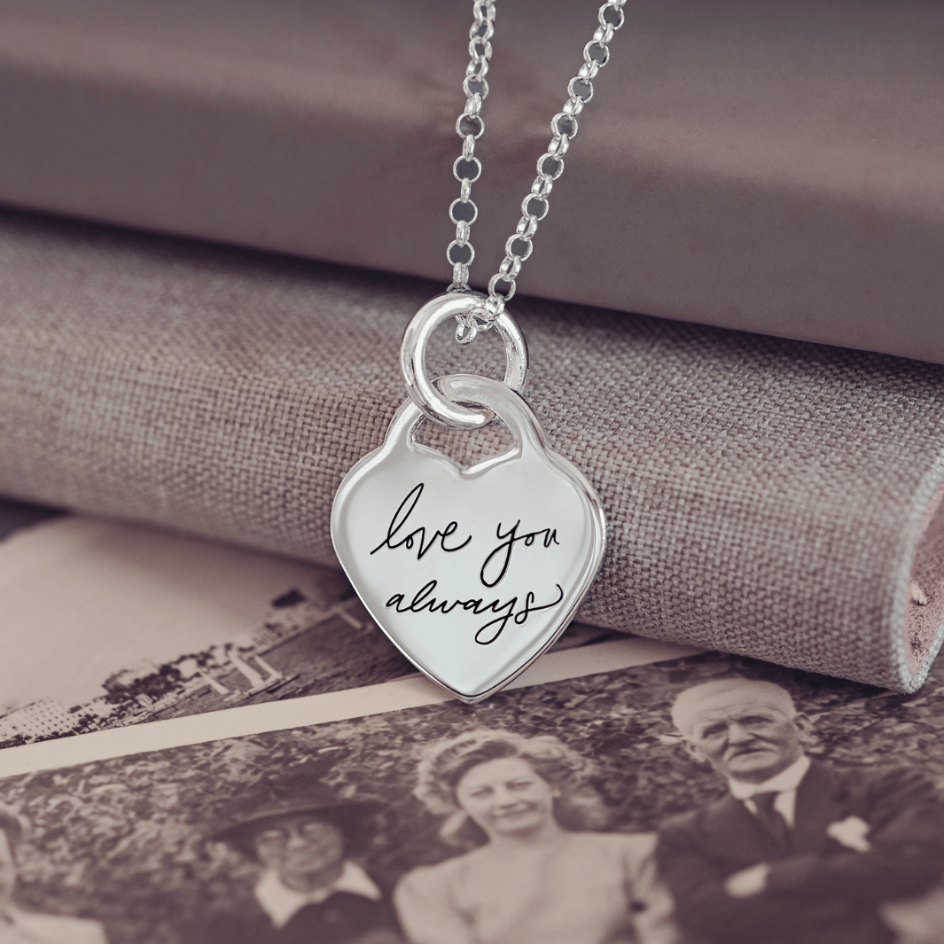 Lock Heart Handwriting Necklace featuring the handwritten message 'Love you always' displayed on a background of old photographs