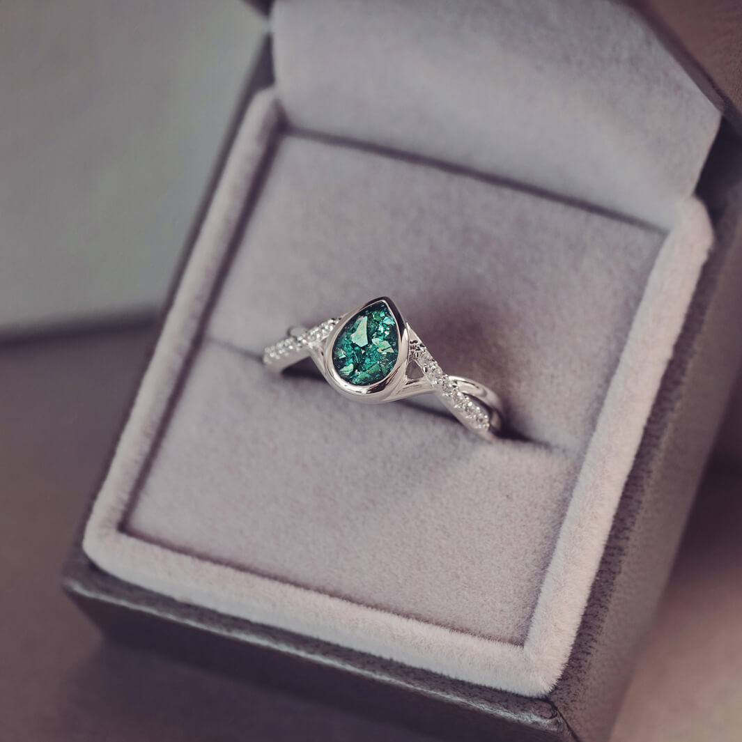 Sterling silver, peardrop shaped ring with a green stone, created using cremation ashes and crystal