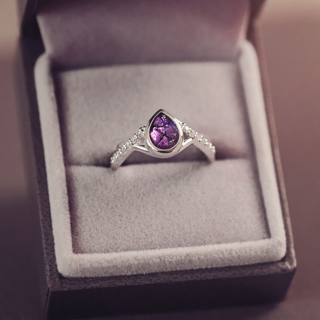 Sterling silver, peardrop shaped ring with a purple stone, created using cremation ashes and crystal