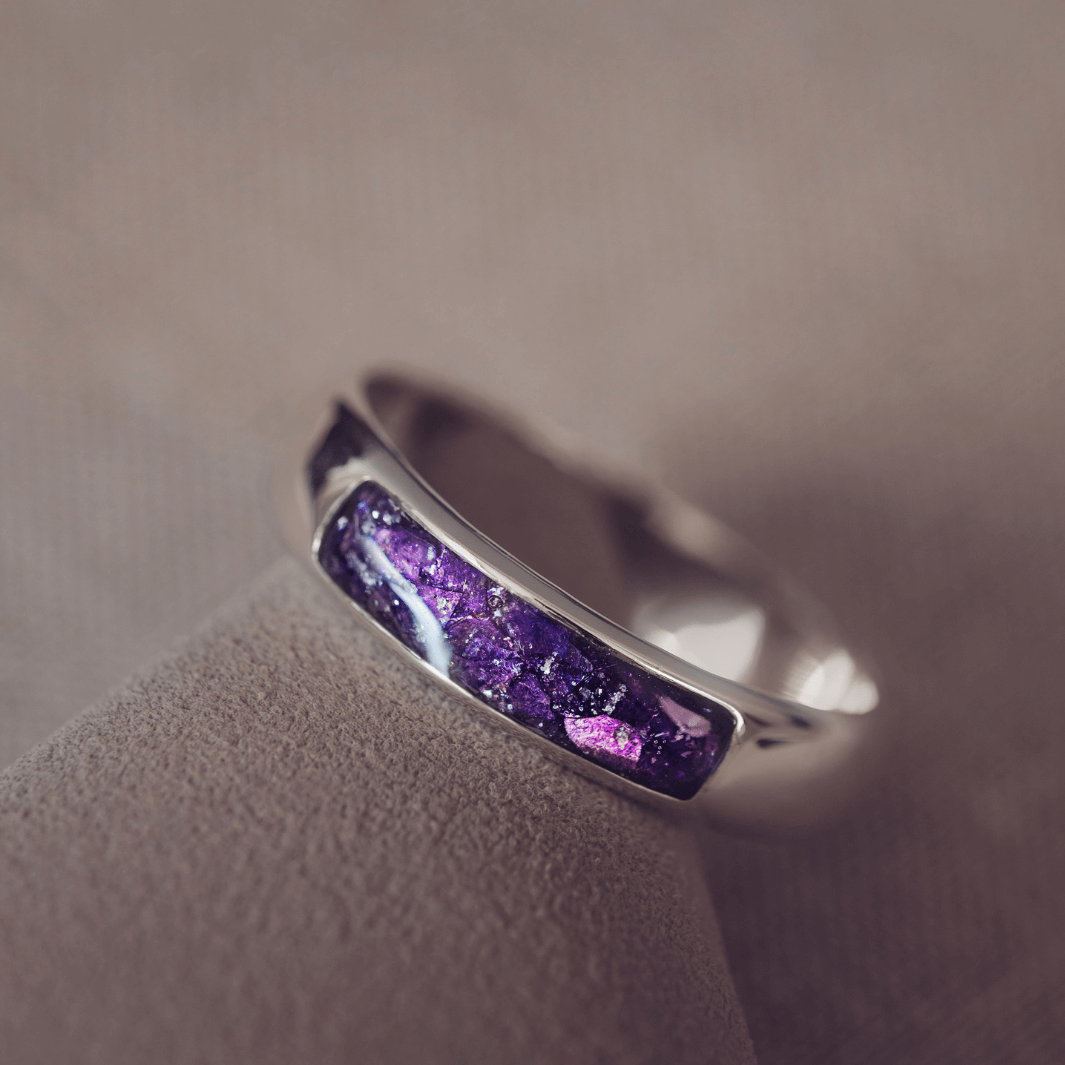 Sterling silver Mens Band Ring with a central section filled with memorial ashes and purple crushed crystals, displayed on a grey background