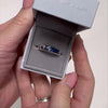 Video of Men’s ashes ring with blue crystal in a jewellery box, being held by a womens hands, showing engraving on inside 