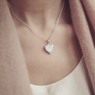 Lady wearing a Sterling silver heart necklace with a central section filled with memorial ashes and white crushed crystals